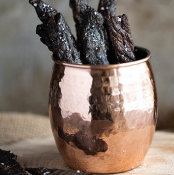 pieces of homemade teriyaki beef jerky in a cup