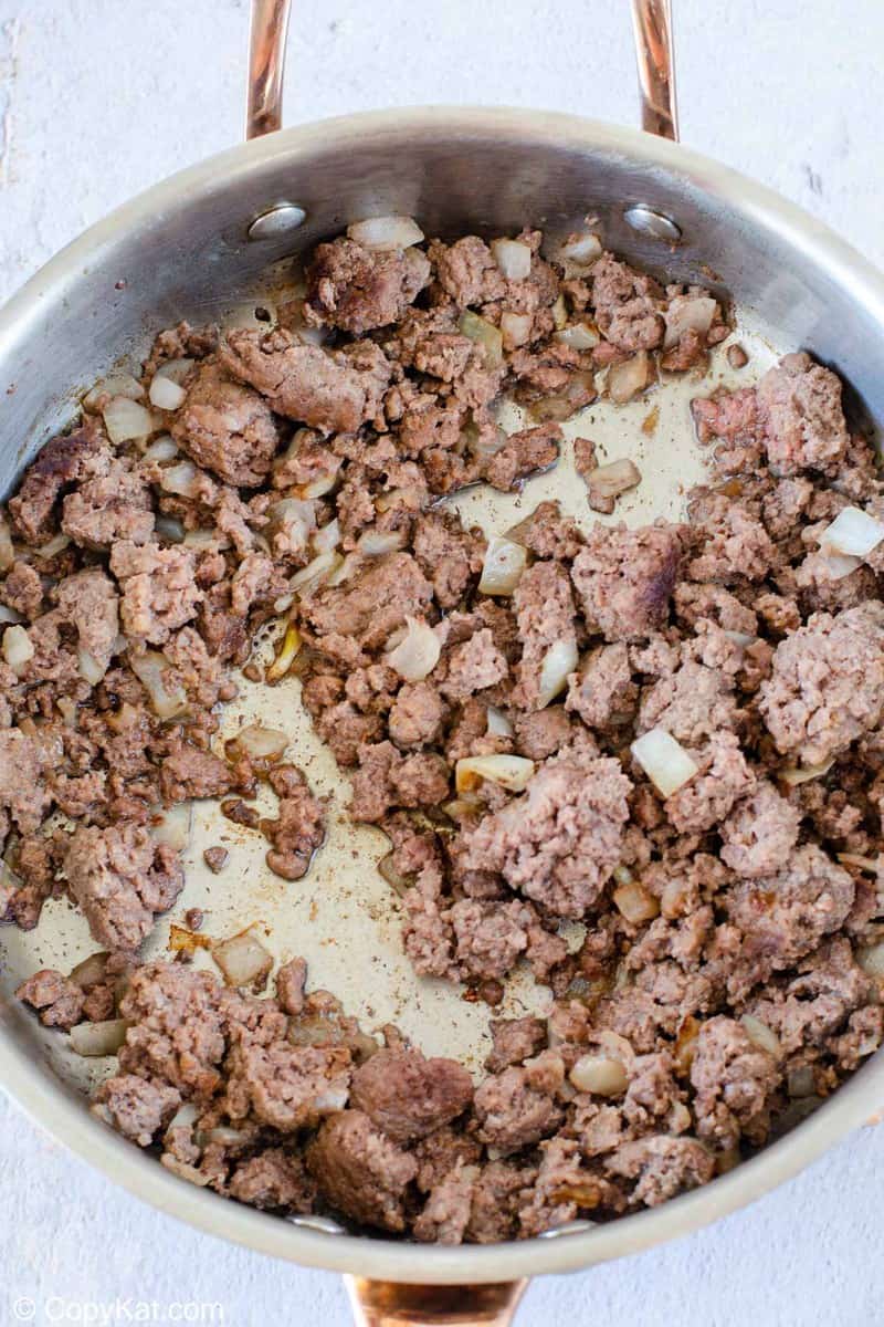 cooked ground beef and onions in a skillet