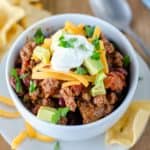 homemade chili topped with cheese, avocado, and sour cream