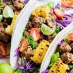 three ground beef tacos with toppings