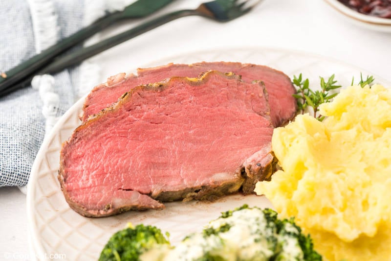two slices of New York strip roast, mashed potatoes, and broccoli on a plate