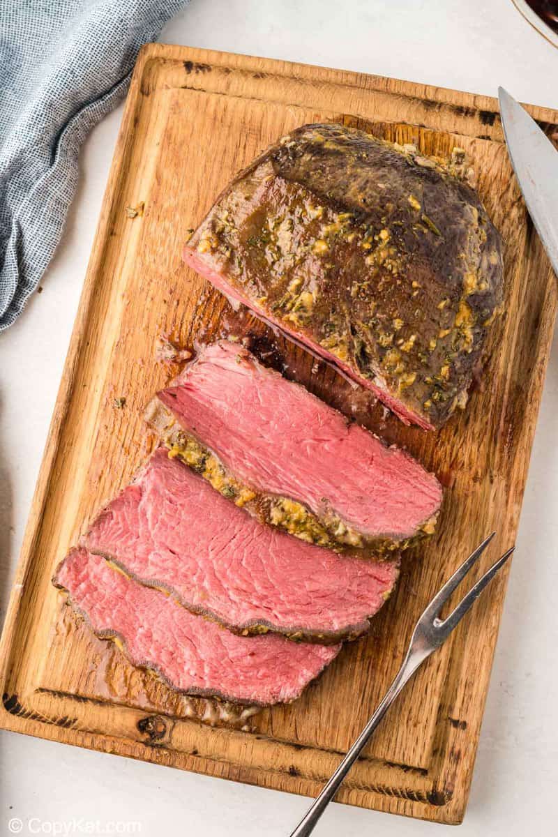 overhead view of cooked and sliced NY strip roast on a cutting board