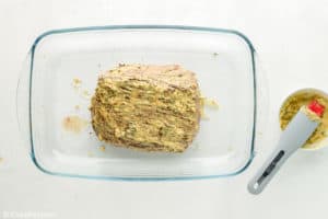 herb seasoned New York Strip Roast in a baking dish before cooking