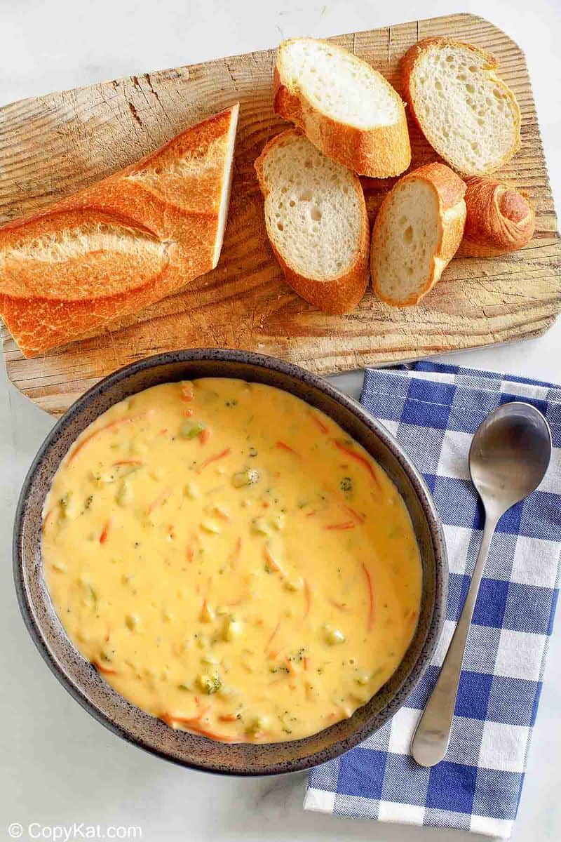 overhead view of a bowl of Panera broccoli cheddar cheese soup and bread slices