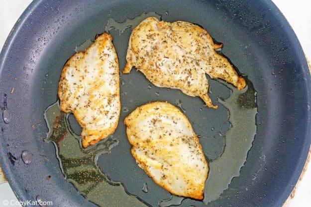 marinated chicken cooking in a skillet