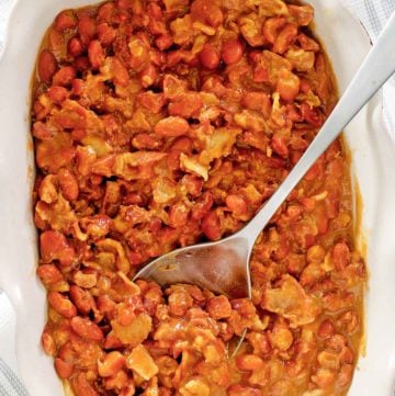 overhead view of BBQ baked beans and a spoon in a serving dish