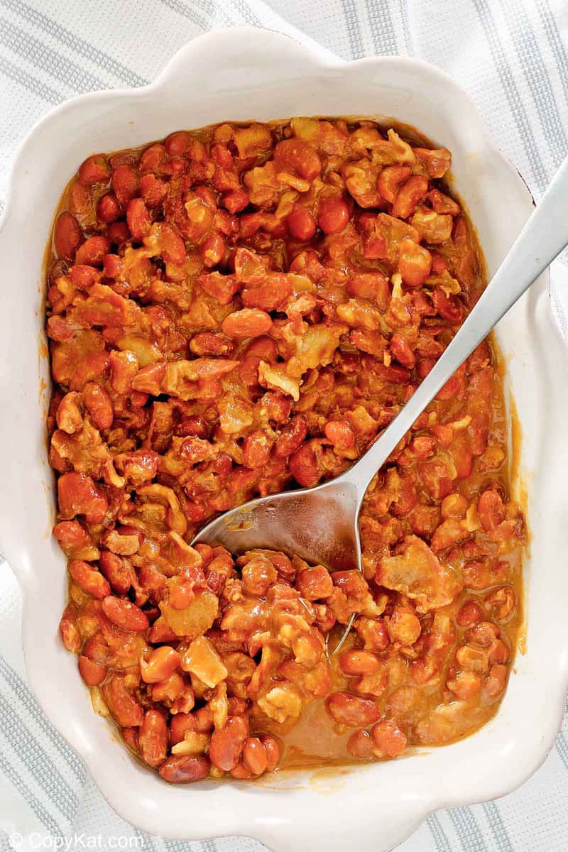 overhead view of BBQ baked beans and a spoon in a serving dish