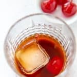 Black Russian cocktail and a bowl of cherries
