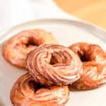 four French cruller donuts on a plate