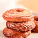 three homemade Dunkin Donuts French Crullers stacked on a plate