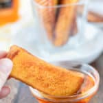dipping a French toast stick in syrup