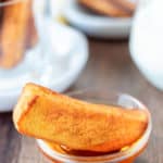 French toast stick in a small bowl of syrup