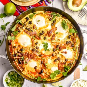 huevos rancheros in a pan, corn tortillas, avocado, and cojita cheese