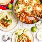 overhead view of huevos rancheros in a pan and on two plates
