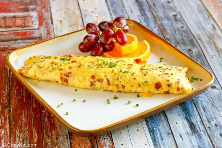 Fluffy omelet stuffed with crispy bacon, melted cheese, and diced tomatoes.