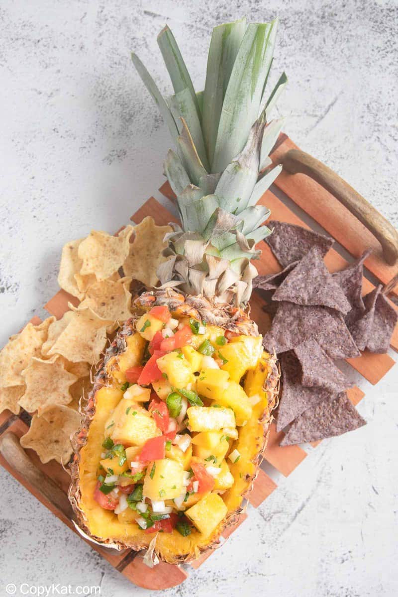 overhead view of pineapple mango salsa in a pineapple and tortilla chips
