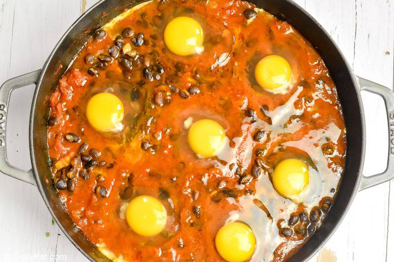 raw eggs in the sauce for huevos rancheros