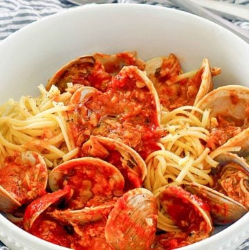 red clam sauce, clams, and pasta in a bowl