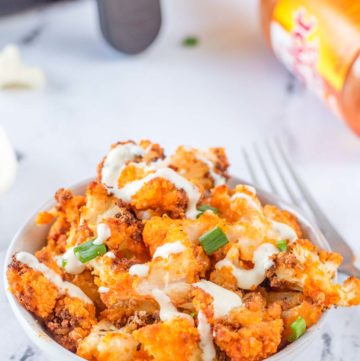air fried buffalo cauliflower with dressing drizzled on top