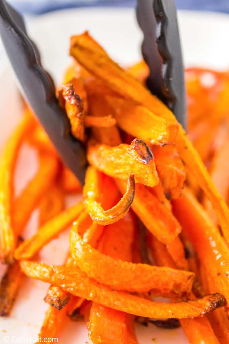 tongs holding air fried carrots