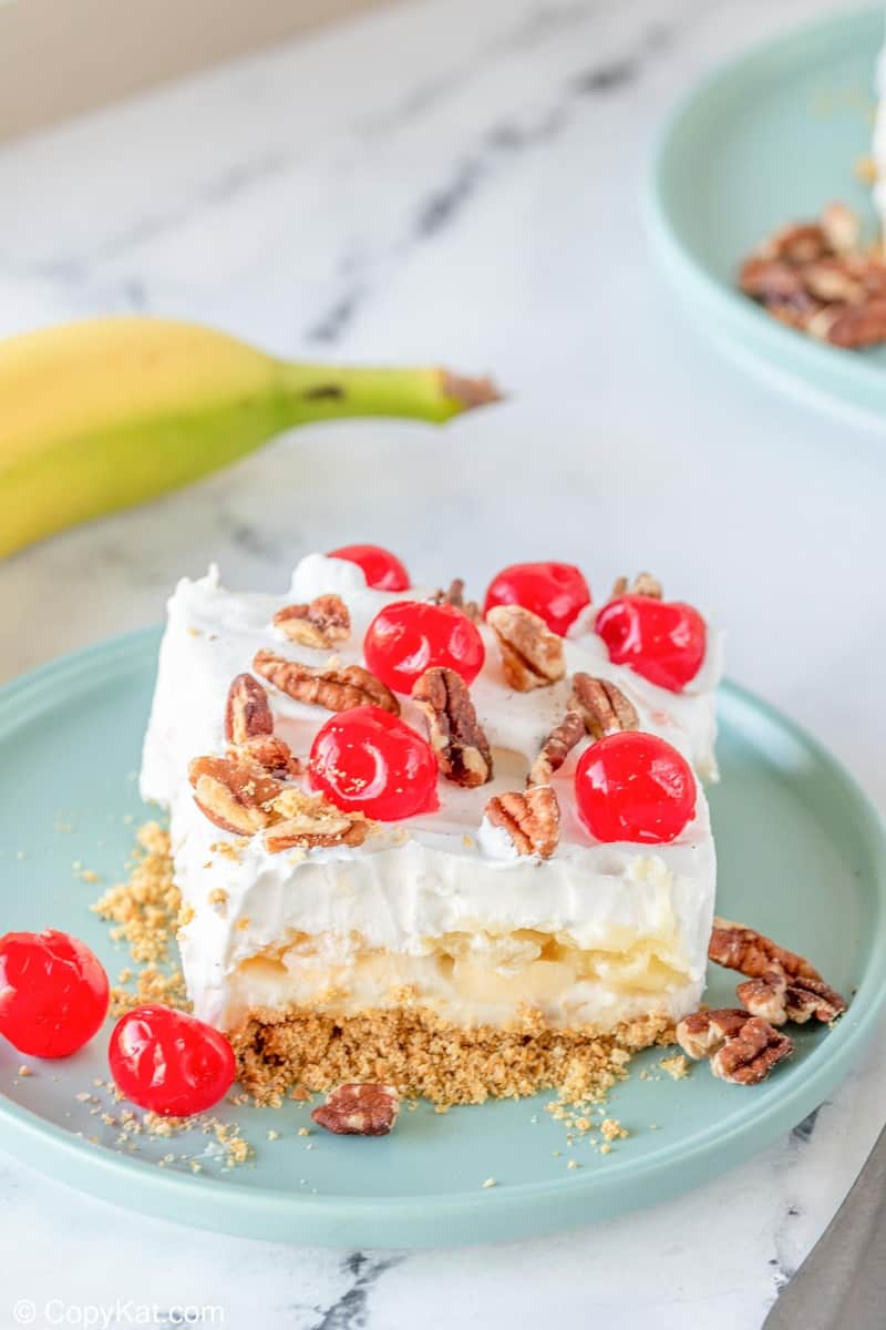 banana split cake slice on a plate next to a banana