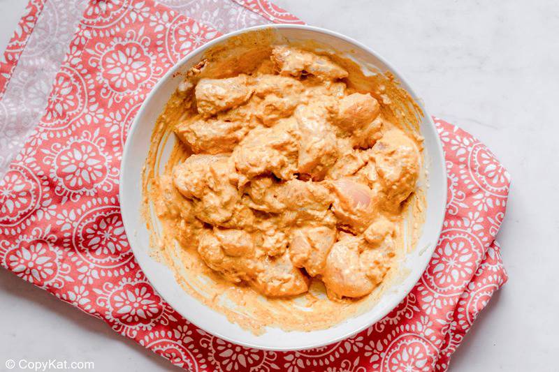 chicken pieces and marinade for butter chicken in a bowl