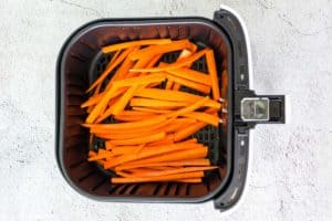 carrot sticks in an air fryer basket