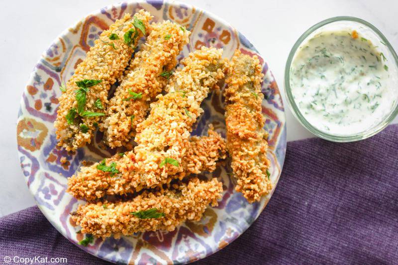 homemade Disney fried pickles next to a bowl of ranch dressing