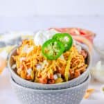 Frito Pie in a bowl set inside of another bowl