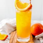 fuzzy navel drink with an orange wedge on top