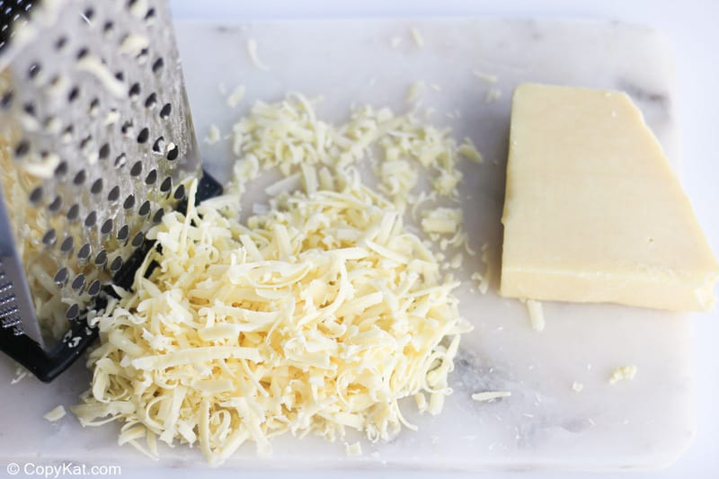 shredded white cheddar cheese and a grater