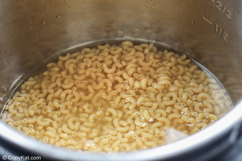macaroni, water, and chicken broth in an Instant Pot