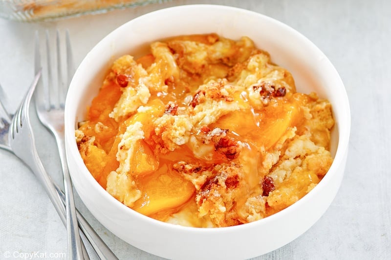 three forks and a peach dump cake in a bowl