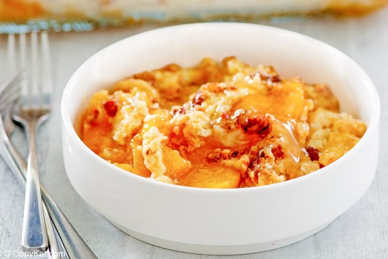 peach dump cake in a bowl and two forks