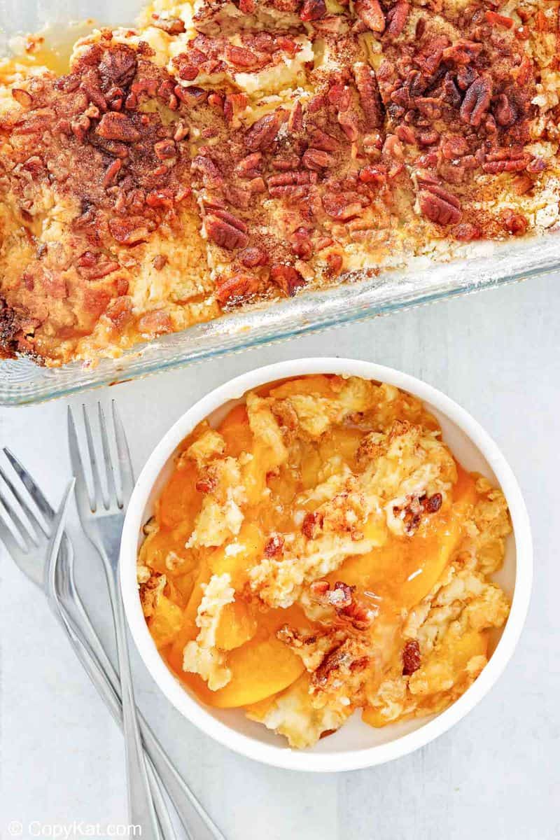 overhead view of peach dump cake in a baking dish and a bowl