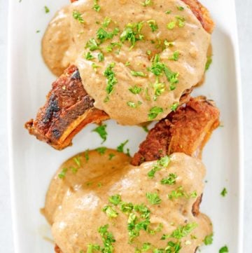 overhead view of two pork chops and gravy on a platter
