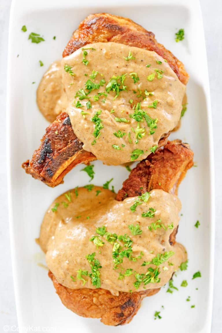 overhead view of two pork chops and gravy on a platter