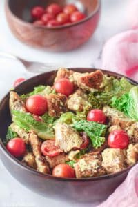 chicken Caesar salad and cherry tomatoes in wood bowls