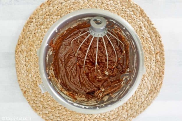 chocolate pudding mixture and a mixer whisk in a bowl