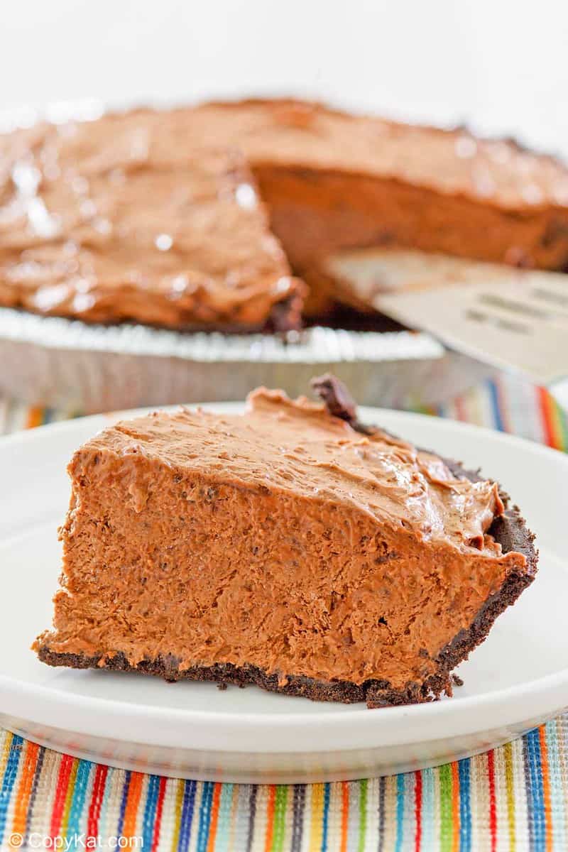 a slice of chocolate pudding pie on a plate in front of the pie