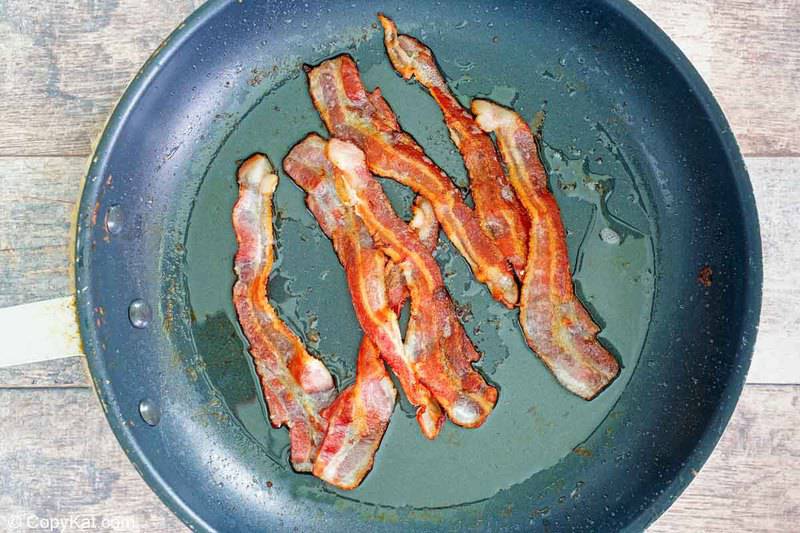 cooked bacon strips in a skillet