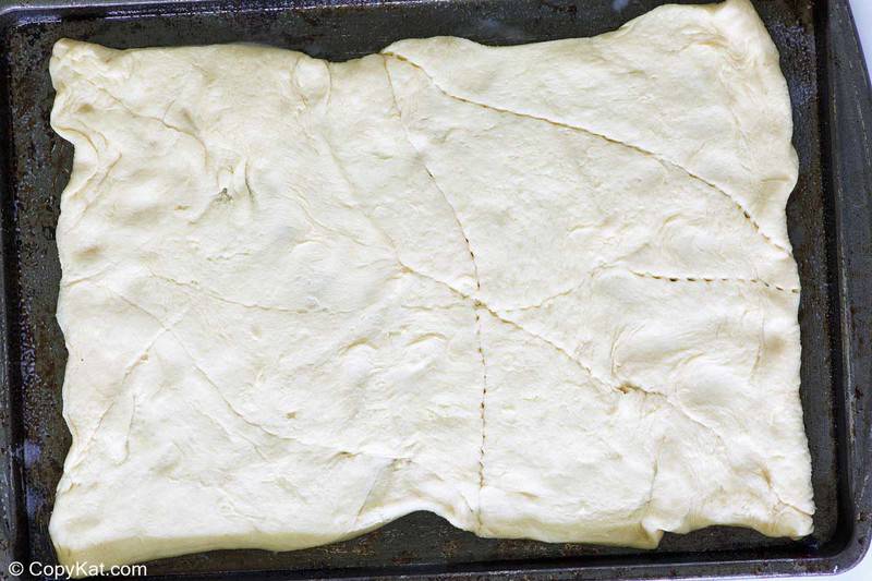 crescent rolls rolled out on a baking sheet