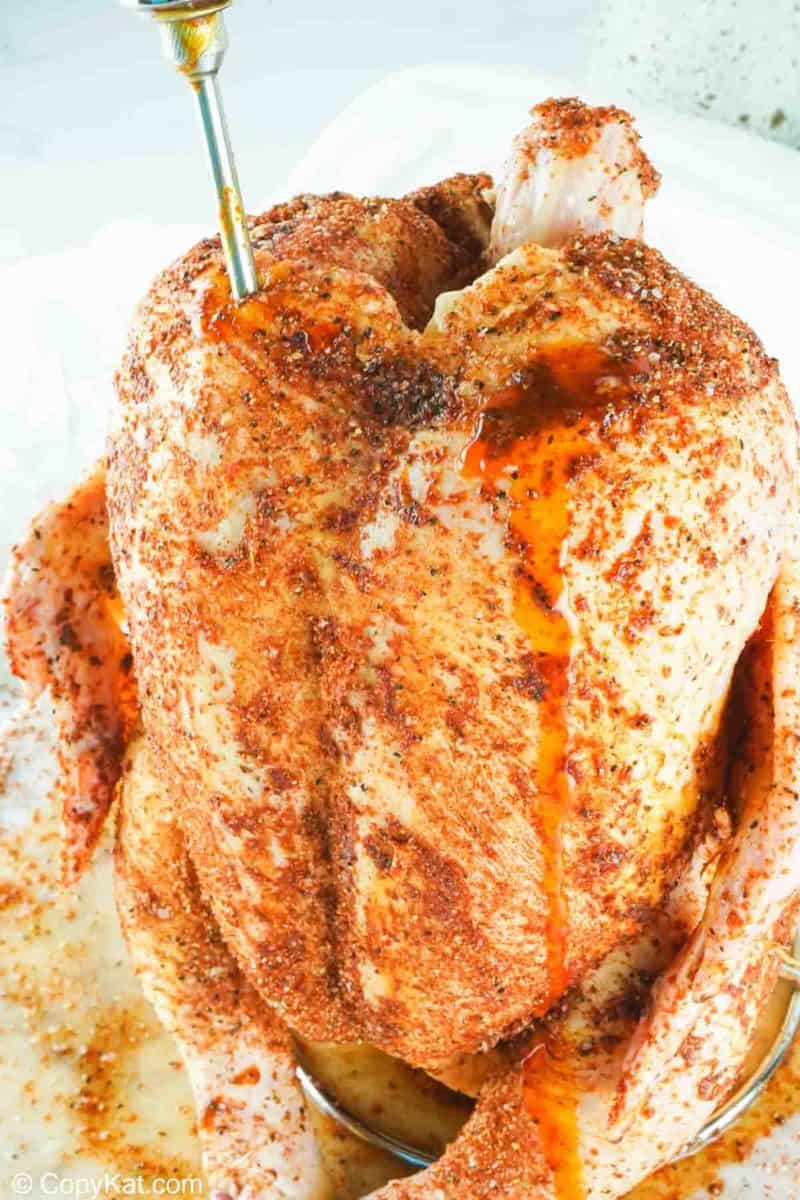 injecting seasoned butter into a chicken