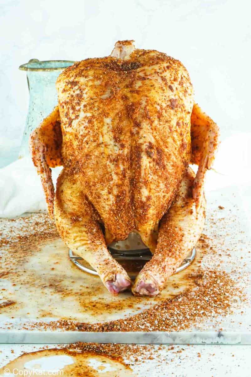 seasoned whole chicken on a beer can chicken holder