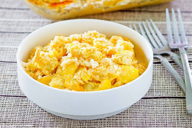 a bowl of squash casserole next to three forks