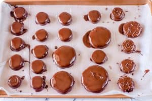 chocolate dipped peppermint patties on a baking sheet
