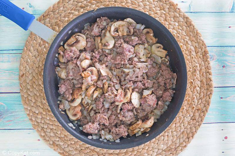 cooked ground beef, Italian sausage, bacon, and onions in a skillet