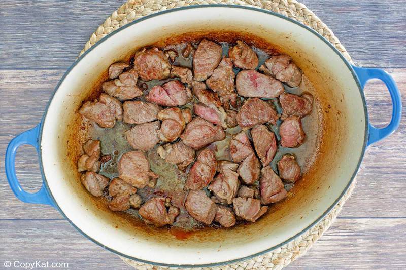 browned lamb pieces in a Dutch oven