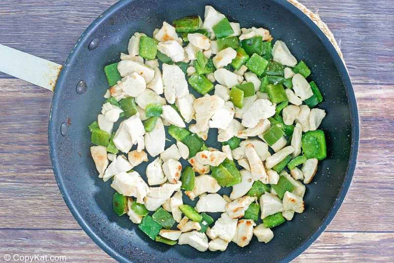 chicken and bell pepper pieces in a skillet