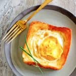 overhead view of egg in a basket and a fork on a plate